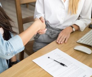 Two women partners handshaking after signing business contract at meeting, female client or customer and manager agent broker closing good deal, female hands shaking making agreement, close up view